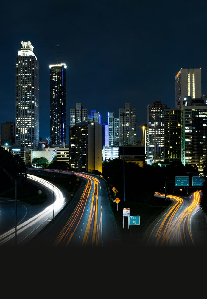 Night city skyline with light trails on a highway
