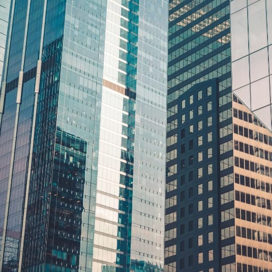 Glass skyscraper facades reflecting surrounding buildings